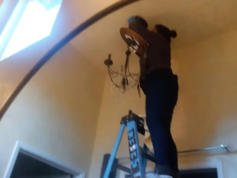 Electrician installing a chandelier in a Missoula residence